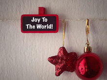 Holiday, Celebration And Christmas Concept. Joy To The World Written On A Wooden Tag. With Blurred Styled Background.
