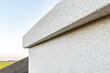 Applying white seamless concrete pebble-dash plaster on chimney.