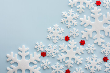 Wall Mural - White and red snowflakes on a blue background, Christmas background, Merry Christmas and Happy New Year concept, top view, copy space