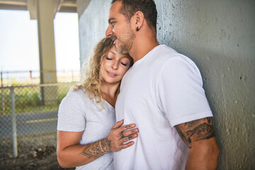 Wall Mural - Beautiful couple having fun outdoors on industrial background