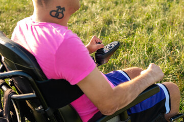 Wall Mural - Disabled man with LGBT tattoo using joystick in electric wheelchair