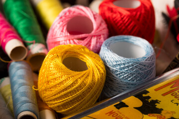 Thread box. box with sewing threads of yellow, red, blue colors in close-up with selective focus. Spools of colored needle threads messy after use