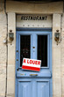 For rent sign ( in French language: a louer) above the entrance door of a restaurant