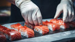Japanese cuisine, the process of making rolls and sushi. A close-up of the hands of a sous-chef preparing Japanese traditional dishes in restaurant kitchen. 