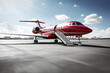 A sleek private jet parked on a tarmac with a red carpet leading to its steps.