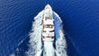 Aerial drone photo of latest technology mega yacht with wooden deck cruising deep blue Mediterranean sea
