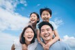 © blvdone - Young happy Asian family with 2 kids smiling lookin up blue sky