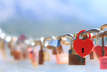 Love Locks And Hearts. Close-up Of Love Lock With A Red Heart Hanging On Chain In On Background Of The Sea. The Key Locks For Lovers Promise Love. Concept Image For Valentine's Day. Loyalty And Love