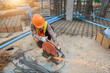 © RooM The Agency - Construction worker cutting steel with a grinder on a construction site, Thailand