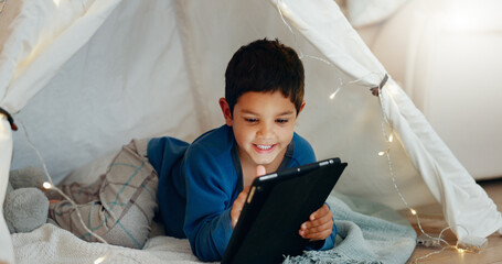 Wall Mural - Tablet, relax and boy child in a tent playing an online game on the internet in the living room. Happy, entertainment and kid watching a movie, video or show on a digital technology in a blanket fort