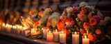 The flickering flames of the candles giving a gentle sway to the flowers and ribbons p at the foot of a memorial, at a candlelit vigil.
