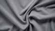 Texture of a knitted cotton jersey fabric, with a stretchy and smooth texture and a heather grey color. The fabric is comfortable and easy to work with, making it a popular choice for tshirts