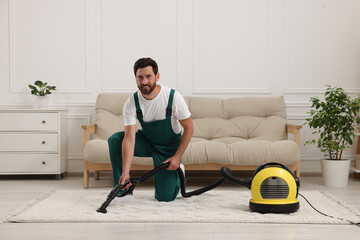 Canvas Print - Dry cleaner's employee hoovering carpet with vacuum cleaner in room