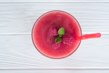 Wall Mural - Raspberry smoothie red colorful fruit juice milkshake blend beverage healthy high protein the taste yummy In glass drink episode morning on white wood background from top view.