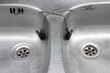 A pair of kitchen sinks with stoppers on a chains