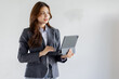 © David - Asian businesswoman hoding digital tablet standing in office isolated on white background, Smiling woman executive manager, Feeling happiness.