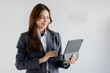 © David - Asian businesswoman hoding digital tablet standing in office isolated on white background, Smiling woman executive manager, Feeling happiness.