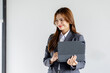 © David - Asian businesswoman hoding digital tablet standing in office isolated on white background, Smiling woman executive manager, Feeling happiness.