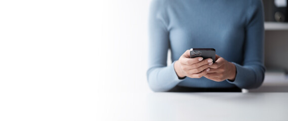 Wall Mural - Businesswoman hands using smartphone mockup at the white office