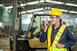 © BESTIMAGE - male maintenance engineer in uniform helmet safety talk by walki talkie and inspection check control heavy machine in industrial factory. technician worker use radio check for repair factory machine