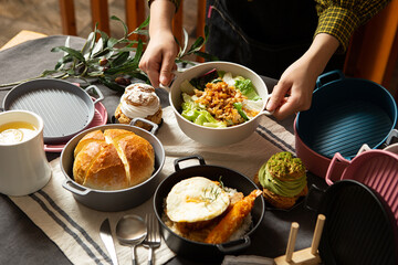 Canvas Print - Various foods on the table, hands holding food