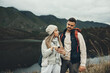 © Rene L/peopleimages.com - Couple, phone and hiking by lake or nature with online search for direction, guide or map on carbon footprint journey, Confused people lost in mountains with backpack, travel and check for location