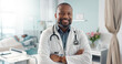 Medicine, doctor and black man with arms crossed at hospital with smile for support, service and wellness. Healthcare, professional and African expert with happiness and pride for career and surgery