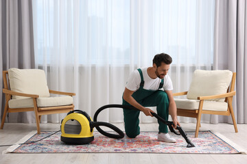 Wall Mural - Dry cleaner's employee hoovering carpet with vacuum cleaner in room