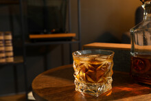 Bottle And Glass Of Whiskey On Wooden Table In Room, Space For Text. Relax At Home