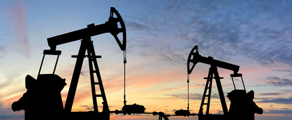 Wall Mural - Oil pump jack. Oil industry equipment rig silhouette against sunset sky clouds background