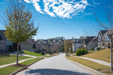 Three story, row of two-story houses along residential street leading down a steep hill in new development suburban neighborhood outside Atlanta, Georgia, USA, upscale homes