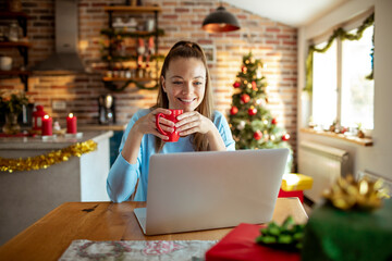 Young woman using a laptop at home during the Christmas holidays