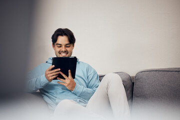 Poster - Happy man, tablet and relax on sofa for social media, communication or entertainment in living room at home. Male person, smile and lying on lounge couch with technology for online streaming at house