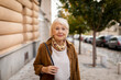 © Marko Geber - Portrait of a senior woman standing on the street in the city