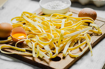 Poster - Homemade pasta tagliatelle. On white table.