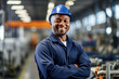 Smiling black man is a professional worker in a hard hat in a factory