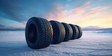 Fototapeta Mapy - Stack of brand new tires against the backdrop of a beautiful winter landscape at dawn, concept of Blur