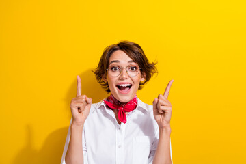 Poster - Photo of young funky girl brown bob hair indicating fingers up above her head crazy introduction advert isolated on yellow color background