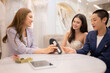© Wosunan - In the wedding dress shop, an LGBT couple selects and pays for bridal and groom outfits.