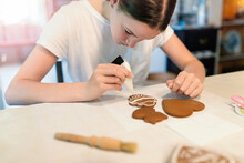 Girl Decorating Gingerbread Cookies With Icing Sugar. Selective Focus.