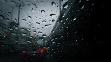 rain droplets on a car windshield, showing the wiper and the blurred traffic