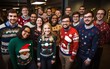 Office employees celebrate the Christmas party of ugly sweaters. Dressed up business people in beautiful and diverse sweaters at a corporate party.