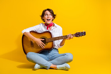 Poster - Photo of positive girl professional guitarist wear stylish clothes sitting floor looking empty space isolated on yellow color background