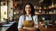 Happy Hispanic female chef smiling and  doing arm crossed gesture confidently in the restaurant.