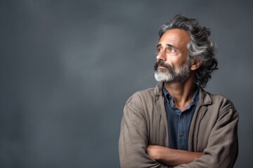 Wall Mural - middle age adult man thinking with pensive expression against wall background. ai generated