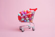 © ADDICTIVE STOCK - Generative AI illustration of composition of miniature shopping trolley cart with assorted multicolored sweets placed near fallen sweets on pink background