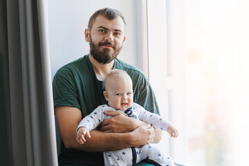 Father hugs baby boy son in living room. Concept lifestyle parenting fatherhood moment