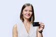 © Valerii Honcharuk - Young woman bank employee showing credit card, on white background