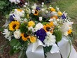 Blumen im Trauerkranz nach Beerdigung auf dem Friedhof 