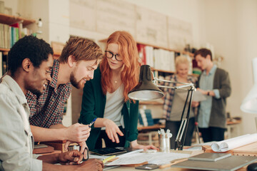 Wall Mural - Young and diverse group of architects working on a project together in a startup company office